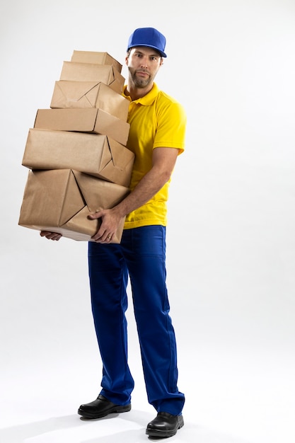 Postino brasiliano su uno sfondo bianco che consegna un pacchetto. copia spazio.