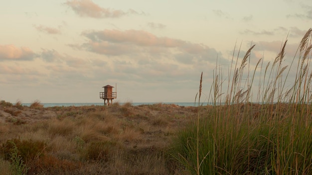 Posto di bagnino in legno su una spiaggia solitaria al tramonto