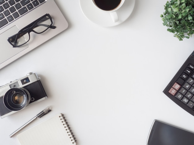 Posto di lavoro con tazza di caffè, taccuino e fotocamera