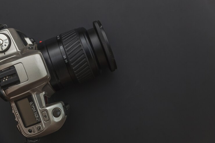 Posto di lavoro del fotografo con il sistema della macchina fotografica del dslr sulla tavola del nero scuro