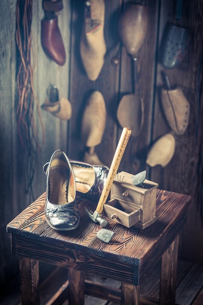 Posto di lavoro di calzolaio invecchiato con strumenti scarpe e pelle