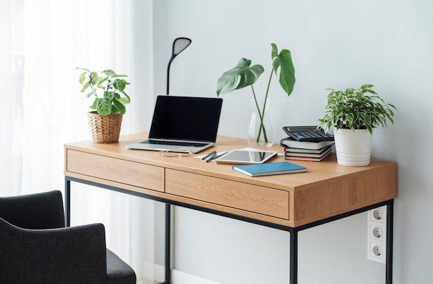 Posto di lavoro in ufficio con laptop su tavolo in legno