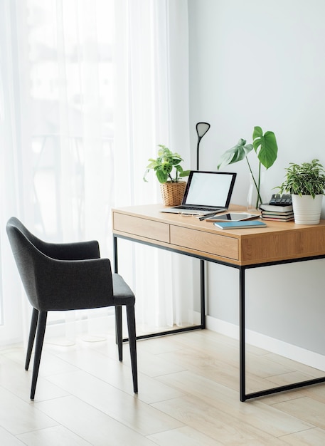 Posto di lavoro in ufficio con laptop su tavolo in legno