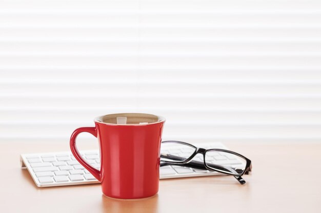 Posto di lavoro in ufficio con occhiali per pc e caffè