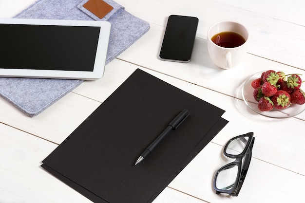 Posto di lavoro moderno con computer tablet digitale e telefono cellulare tazza di caffè penna e foglio vuoto di ...