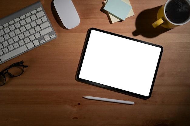 Posto di lavoro semplice con tavolette digitali bicchieri da caffè e note adesive su tavola di legno Vista dall'alto