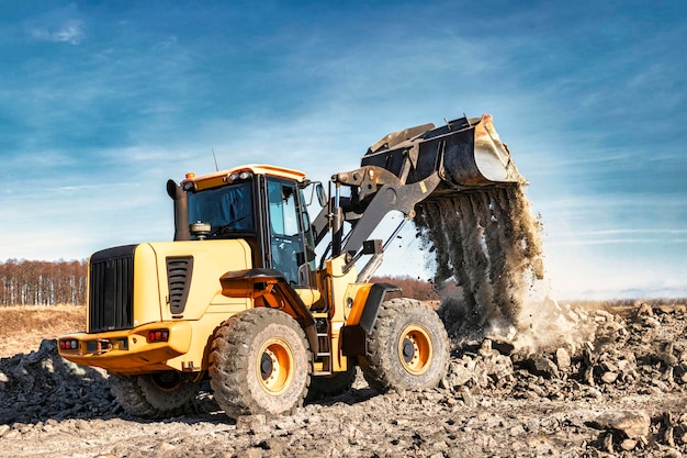 Potente pala gommata o bulldozer che lavora in una cava o in un cantiere Lavori di sterro in costruzione Potenti attrezzature moderne per lavori di sterro