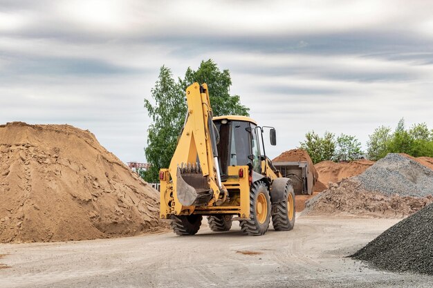 Potente pala gommata o bulldozer in cantiere Il caricatore trasporta la sabbia in un secchio di stoccaggio Potenti attrezzature moderne per lavori di sterro e movimentazione di rinfuse