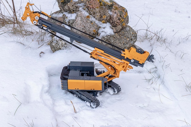 Potente perforatrice idraulica per l'installazione di pali trivellati in inverno sulla neve in cantiere. Impianto di perforazione nel nord. Albero piegato. Messa a fuoco selettiva.