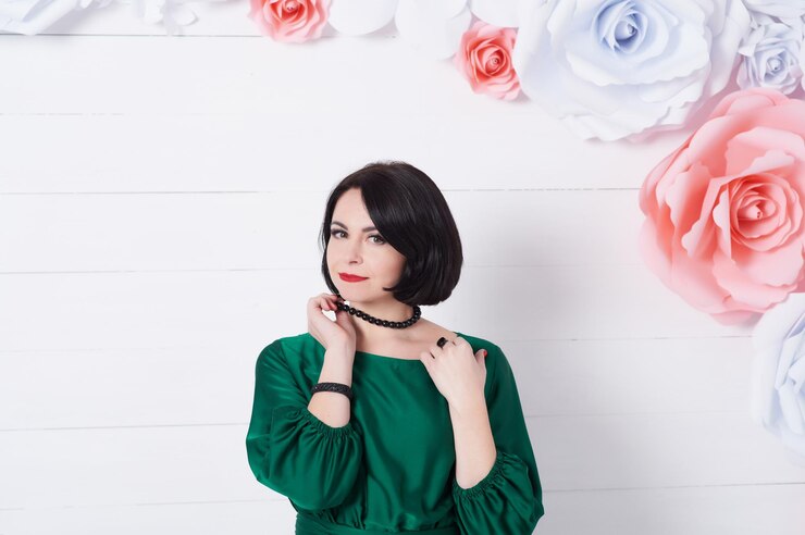 Photo potret wanita muda cantik berdiri di depan dinding