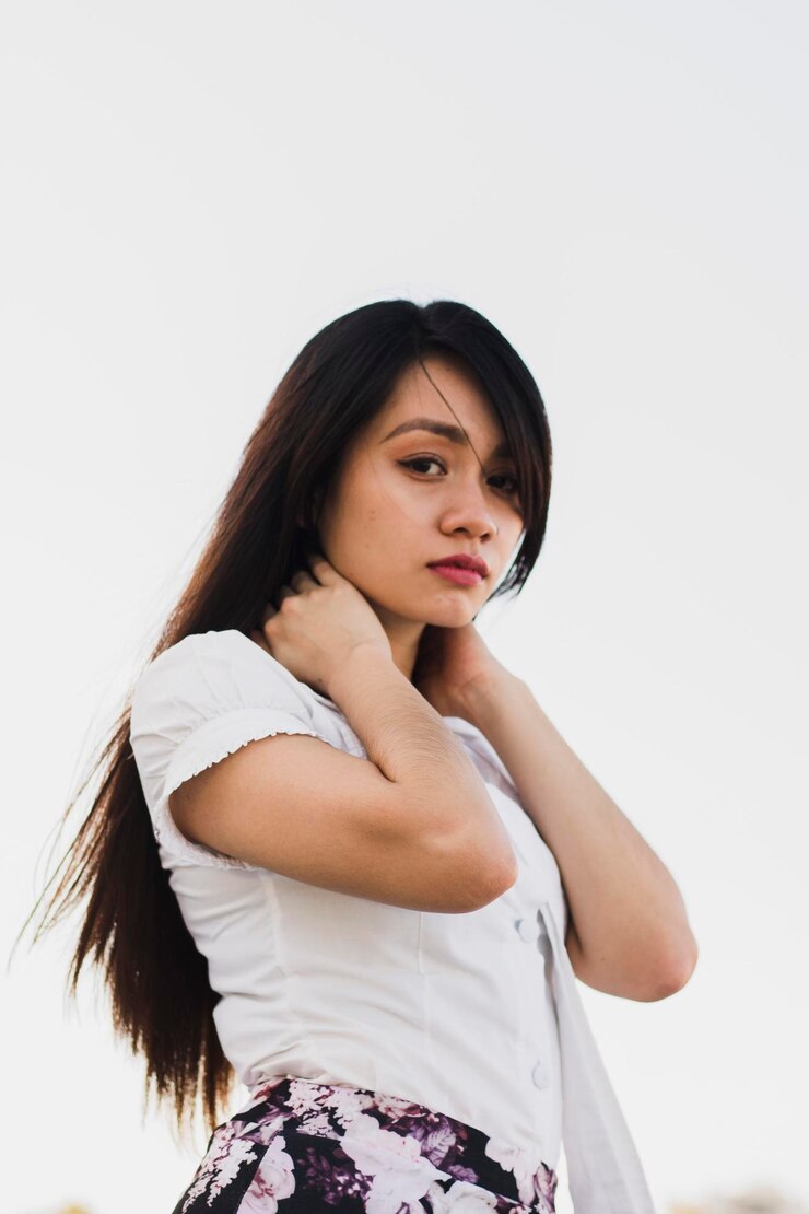 Photo potret wanita muda yang berdiri di depan latar belakang putih