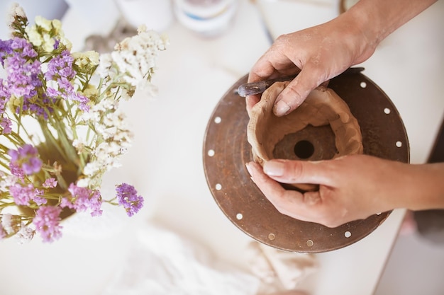 Potter femminile che crea una ciotola. Mani di fabbricazione del vaso di argilla. Abilità di ceramica dell'artista artigiano.