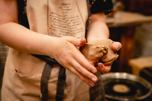Potter lavorando al tornio con argilla. Processo di produzione di stoviglie in ceramica nel laboratorio di ceramica. Concetto di artigianato e arte.