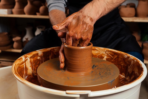 Potter professionale uomo felice che lavora con argilla marrone in officina. uomo d'affari artista commercio negozio di pentole fatto a mano