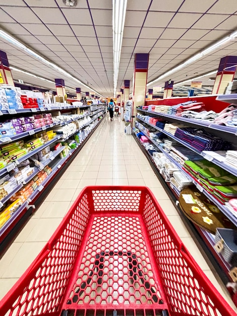 Pov del carrello della spesa nella prospettiva della linea del supermercato Consumismo e prodotti per la casa