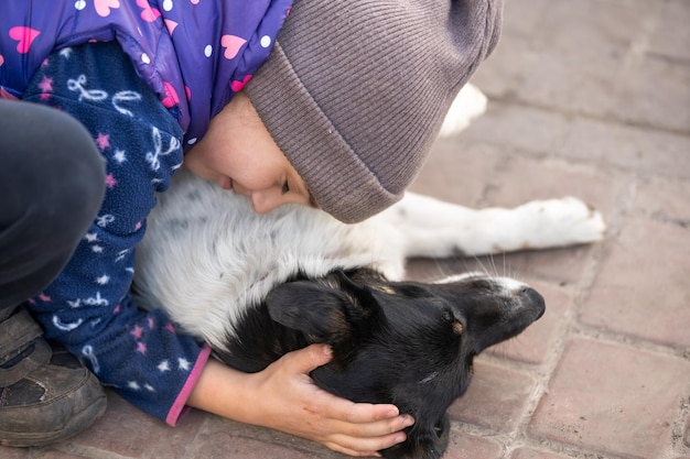 Povera bambina con un cane nel villaggio