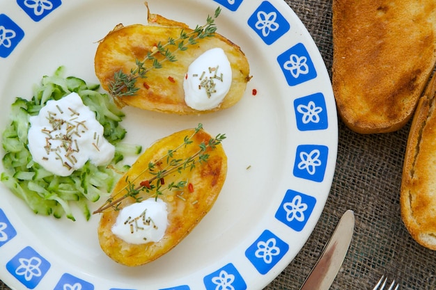 Pranzo vegetariano ipocalorico: patate grigliate con cetrioli, yogurt, timo. Pane alla griglia su tela di sacco