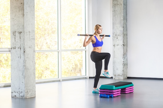 Pratica sportiva della donna sulla piattaforma del gradino. Foto in studio