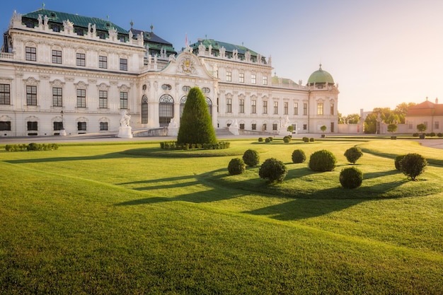 Prato luminoso con piante tagliate davanti al sontuoso palazzo barocco all'alba Vienna Austria