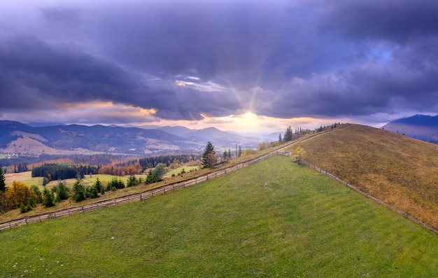 Prato verde o pascolo nelle montagne di autunno all'alba.