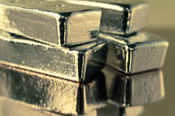 Precious shiny gold bars on color background. Gold ingots for finance and banking concept. Economy trends background for business idea. Trade in precious metals. Close up, Selective focus.