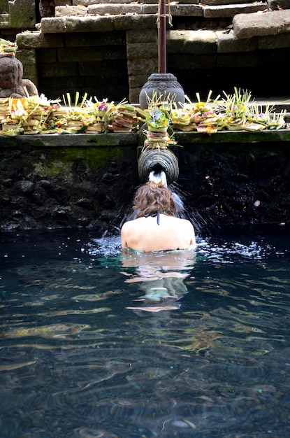 Pregare nell'acqua della sorgente sacra della piscina sacra al Tempio di Pura Tirta Empul