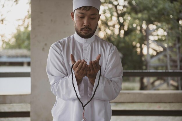 Preghiera dell'uomo islam asiaticoPreghiera dei giovani musulmaniConcetto di festival del Ramadan