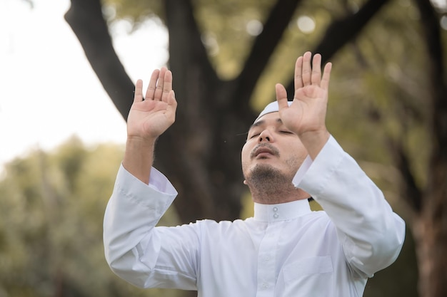 Preghiera dell'uomo islam asiaticoPreghiera dei giovani musulmaniConcetto di festival del Ramadan