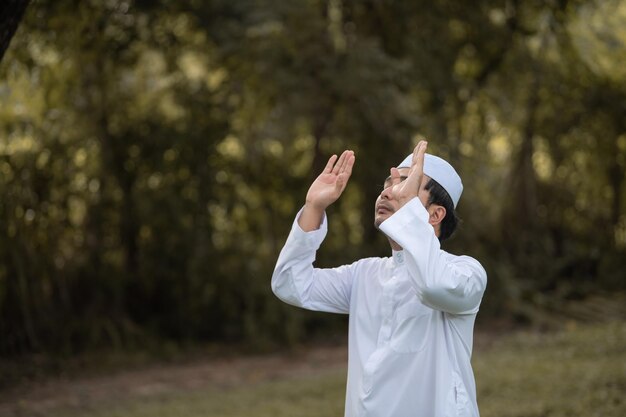 Preghiera dell'uomo islam asiaticoPreghiera dei giovani musulmaniConcetto di festival del Ramadan