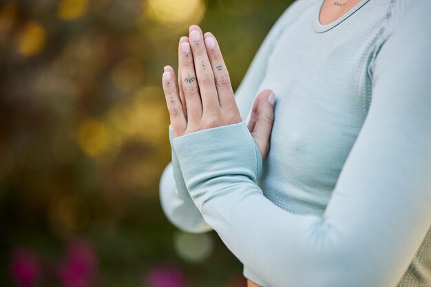 Preghiera yoga e donna zen con le mani in meditazione spirituale gesto pacifico o di adorazione all'aperto nella natura Consapevolezza del benessere e persona sana che si rilassano in un esercizio calmo ed equilibrato