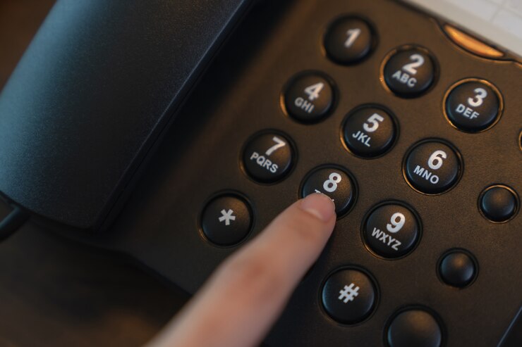 Premere a mano il pulsante del telefono sulla scrivania.