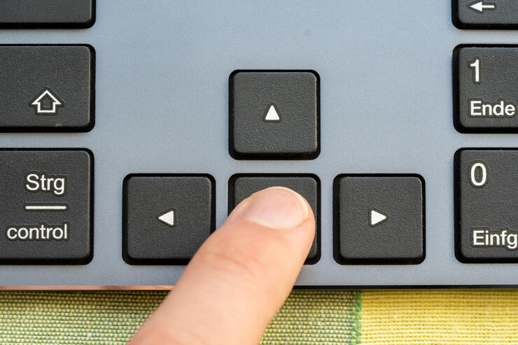 Premere con il dito il tasto freccia indietro sulla tastiera di un computer che indica un'azione inversa