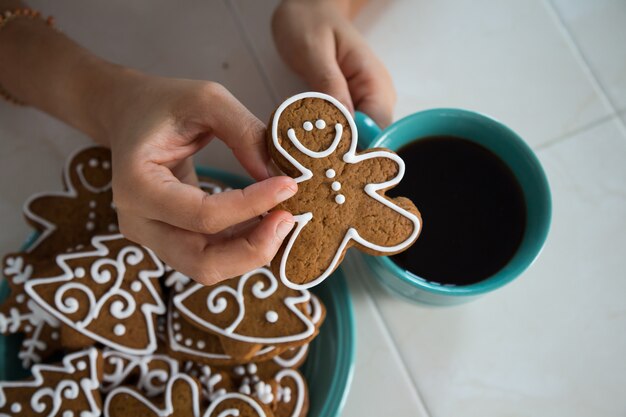 Prendendo un biscotto di pan di zenzero con il caffè