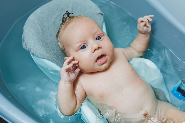 Prendersi cura di un neonato, fare il bagno al bambino, fare il Bagno al bambino nella vasca da bagno, fare il primo bagno ai bambini.