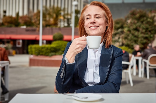 Prendersi un momento per ricaricare una donna d'affari di successo di mezza età si gode una tranquilla pausa caffè