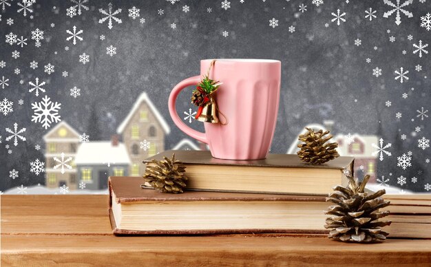 Prenotare. Tazza da tè di Natale sui libri sulla tavola di legno sopra il fondo di lerciume con lo spazio della copia