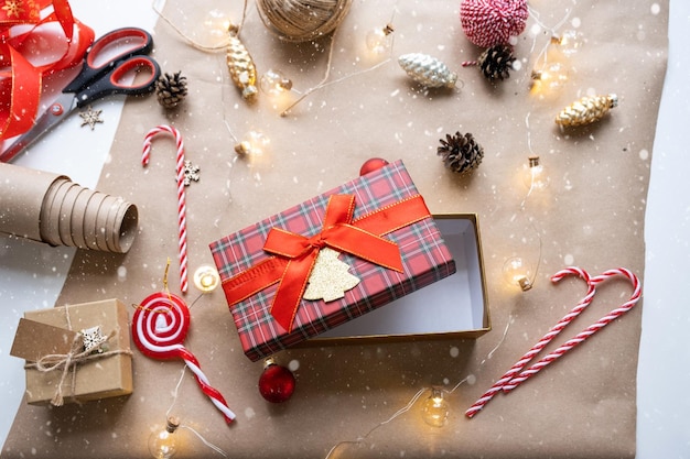 Prepara un regalo per Natale e Capodanno in carta kraft coni nastro forbici Tag con finto decoro naturale fatto a mano umore festivo fai da te sfondo Flatlay