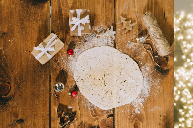 Preparare i biscotti di Natale su una superficie di legno