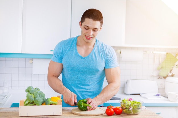 Preparare il cibo tagliare le verdure cucina sana del pasto del giovane che mangia copyspace