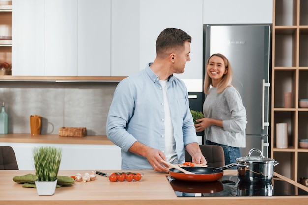 Preparare la cena Coppia a casa sulla cucina moderna