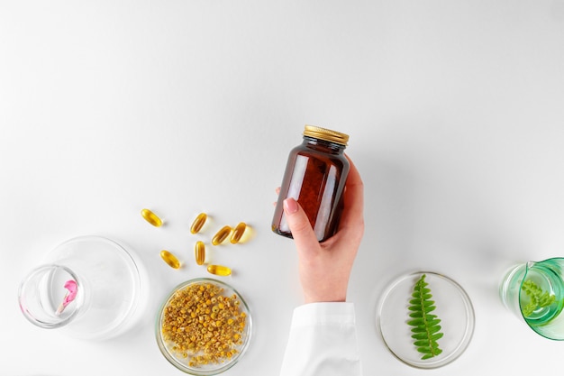 Preparare un integratore alimentare a base di erbe in laboratorio con foglie di piante. Concetto di salute e bellezza