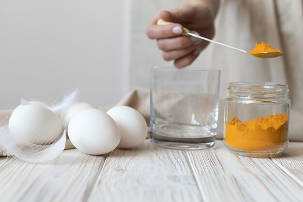 Preparare una soluzione di curcuma secca per tingere le uova per Pasqua. Foto di alta qualità