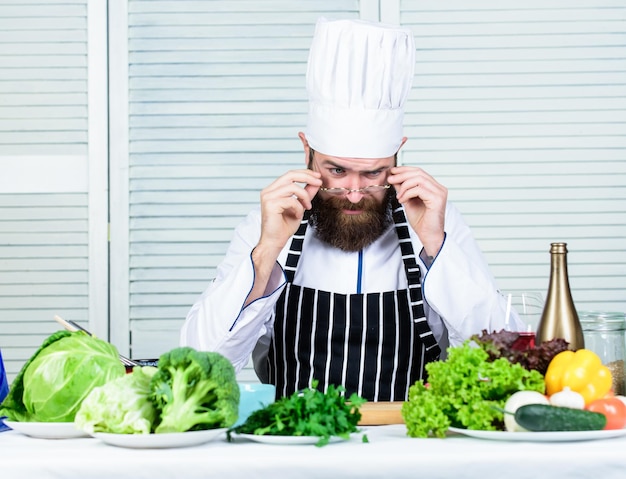 Preparati Chef uomo barbuto che si prepara a cucinare un piatto delizioso Chef al lavoro che inizia il turno Ragazzo in uniforme professionale cuoco pronto Master chef concept Sfida culinaria Chef bello hipster