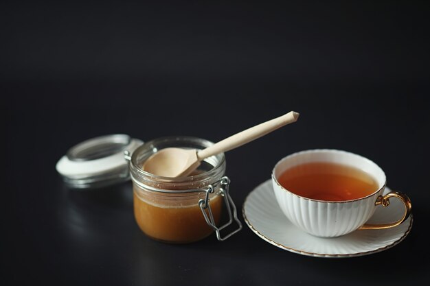 Preparato per la colazione. Dolci e pasticcini con noci per il tè su sfondo nero. Una tazza di caffè e polpette.