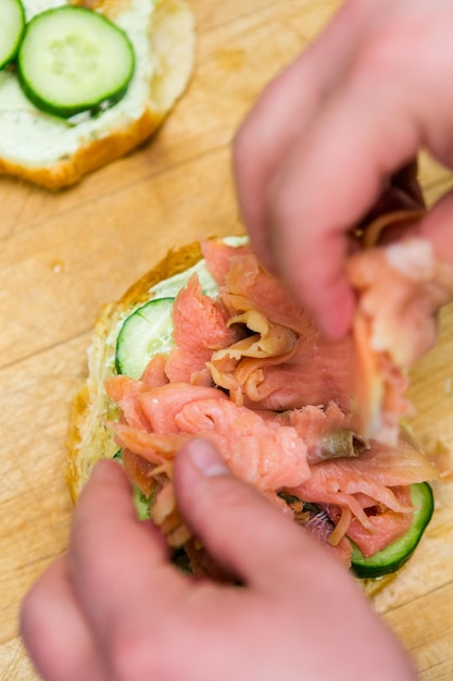 Preparazione del panino delizia lox con croissant fresco.