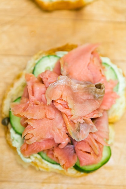 Preparazione del panino delizia lox con croissant fresco.