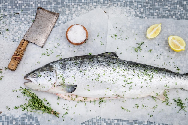 Preparazione del salmone fresco con limone ed erbe aromatiche per la griglia