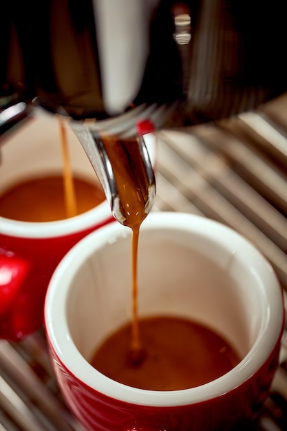 Preparazione dell'espresso in una macchina da caffè Il caffè caldo viene versato in una tazza