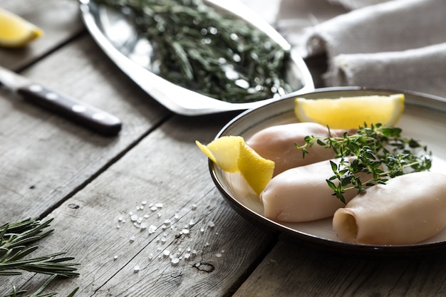 Preparazione di calamari crudi e ingredienti sul tavolo