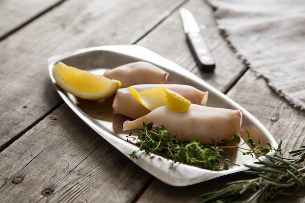 Preparazione di calamari crudi e ingredienti sul tavolo